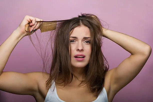 Woman brushing her hair with a wooden comb