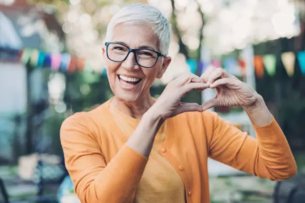 Portrait of a smiling senior woman gesturing outdoors
