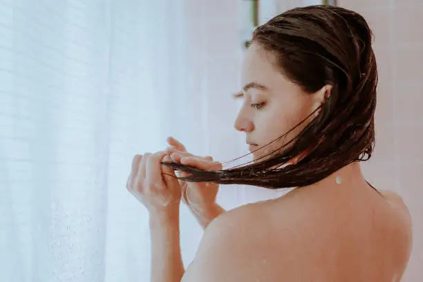 Woman taking a shower and washing her hair at home