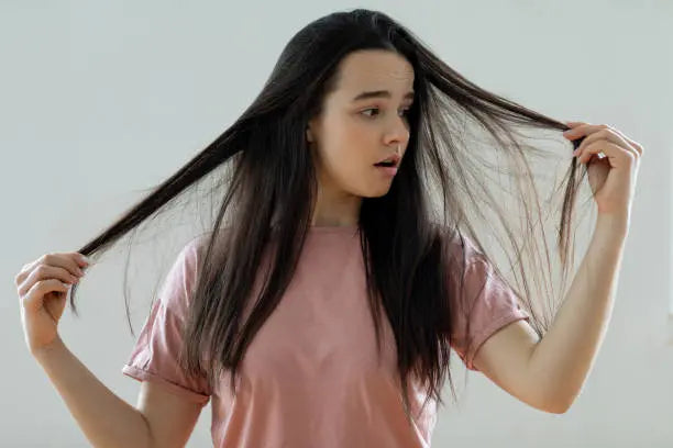 Woman holding damaged dry hair