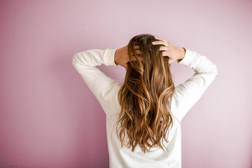 Mujer lavándose el pelo con champú natural sin sulfatos