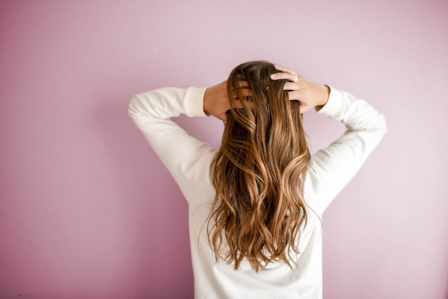 Mujer lavándose el pelo con champú natural sin sulfatos